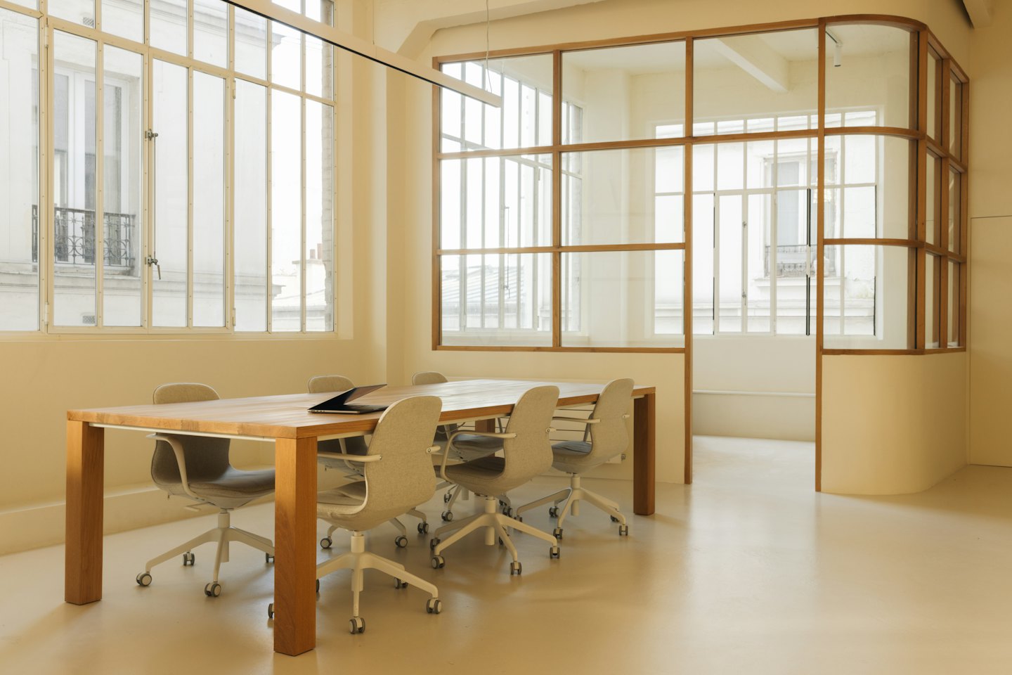Empty modern meeting room with wood table and six chairs.